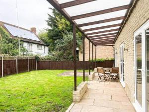 a patio with a wooden pergola in a yard at Luxury 4-bed in Oxford with 2x parking & garden in Oxford