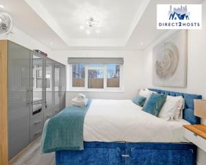 1 dormitorio con 1 cama grande y 1 sofá azul en Bright and Stylish One Bedroom Flat by Direct2hosts Short Lets with great location! en Londres