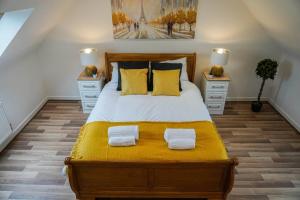um quarto com uma cama grande e almofadas amarelas em Luxury 4-bed in Oxford with 2x parking & garden em Oxford