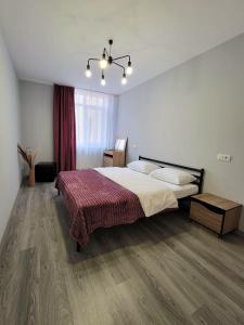 a bedroom with a large bed and a wooden floor at Central Exclusive Ap4you.if in Ivano-Frankivsʼk