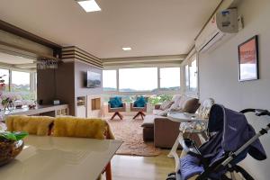 a living room with a couch and a stroller at Residencial via Florida AP102 D in Gramado