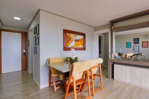 Una cocina y un comedor con mesa y sillas. en Residencial via Florida AP102 D, en Gramado 7 fotos más
