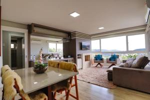 a living room with a table and a couch at Residencial via Florida AP102 D in Gramado