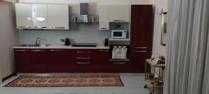 a kitchen with brown cabinets and a microwave at Zappala' Gemelli House in Catania