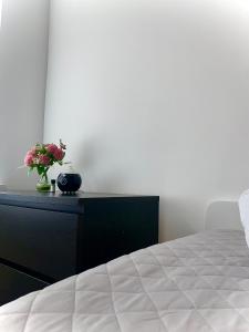 a bedroom with a bed and a dresser with a vase of flowers at @HOME in Chemnitz