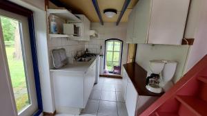 eine kleine Küche mit weißen Schränken und einem Waschbecken in der Unterkunft Holiday Home Achterbos in Sint-Oedenrode