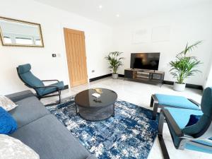 a living room with a couch and chairs and a tv at Luxury Modern Private Villa in Brighton in Brighton & Hove