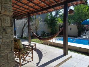 a hammock on a patio next to a swimming pool at Casa em Itaipu in Niterói