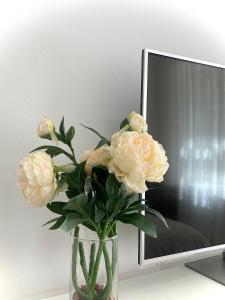 a vase with flowers in front of a tv at @HOME in Chemnitz