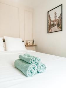Una cama blanca con tres toallas. en Appartement vue sur château-fort 3 étoiles, en Sedan