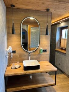 ein Bad mit einem Waschbecken und einem Spiegel in der Unterkunft Hotel Sonnekalb in Naumburg