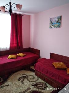 a bedroom with two beds and a window at Деспина in Balchik