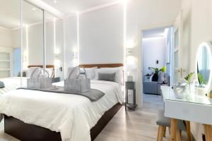- une chambre blanche avec un grand lit et un miroir dans l'établissement Precioso Apartamento cerca de la Puerta Del Sol, à Madrid