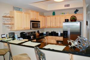 a kitchen with wooden cabinets and a stainless steel refrigerator at Holiday Isle 412 in Dauphin Island