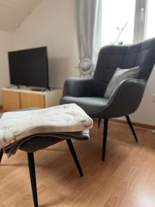uma sala de estar com um sofá e uma cadeira em Dachgeschosswohnung in Weiherhammer em Weiherhammer