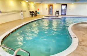 a swimming pool at a hotel with chairs and tables at Holiday Isle 412 in Dauphin Island +13 photos