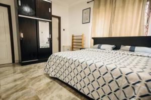 een slaapkamer met een bed met een zwart-wit dekbed bij OG Residence in Accra