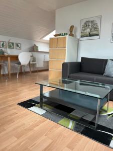 uma sala de estar com um sofá e uma mesa de vidro em Dachgeschosswohnung in Weiherhammer em Weiherhammer