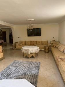 ein Wohnzimmer mit Couch und Tisch in der Unterkunft MEKNES-villa avec piscine-MAROC in Meknès