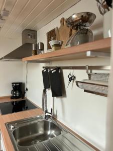 uma cozinha com um lavatório e prateleiras de madeira em Dachgeschosswohnung in Weiherhammer em Weiherhammer