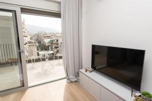 ein Wohnzimmer mit einem Flachbild-TV an der Wand in der Unterkunft Brand-new flat with a city view (FORM_G1) in Athen