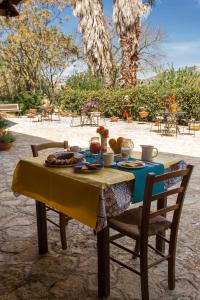 a table with food on top of it with chairs at Agriturismo Tarantola in Alcamo