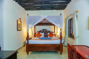 a bedroom with a bed with a canopy at Al Johari Hotel & Spa in Zanzibar City
