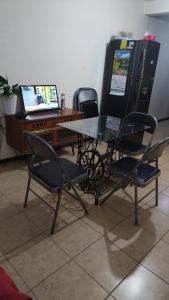 a glass table with chairs and a desk with a computer at Habitacion privada in Tehuacán