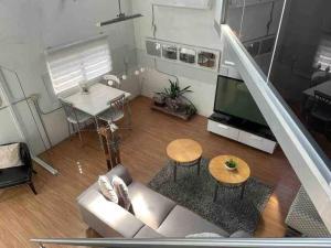 a living room with a white couch and a television at Centric Rustic Modern Downtown Executive Pad in Mayaguez