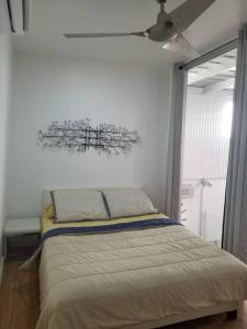 1 dormitorio con 1 cama con lámpara de araña encima en Centric Rustic Modern Downtown Executive Pad, en Mayagüez