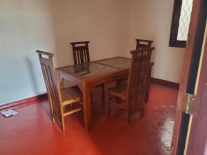 uma mesa de madeira e duas cadeiras e uma mesa e uma mesa e uma mesa em Mount lavinia home em Watumulla