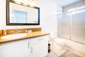 a bathroom with a sink and a toilet and a mirror at Large Condo Sleeps 10 near Downtown Los Angeles in Los Angeles