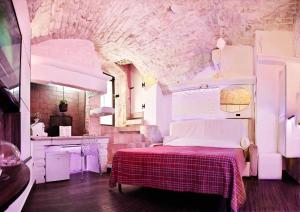 a bedroom with a bed with a red and white blanket at l'angolo di Gaudì, alcoba Capriccio in Putignano