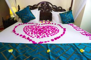 a bed with a heart made out of pink flowers at Al Johari Hotel & Spa in Zanzibar City