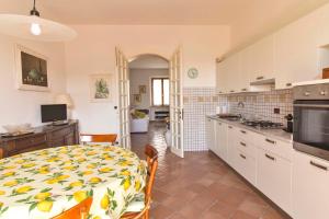a kitchen and dining room with a table with a yellow and white table cloth at Appartamento Donella con parcheggio privato in San Gimignano