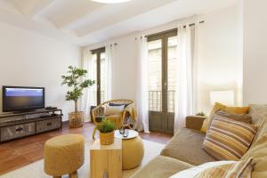 a living room with a couch and a tv at Columbus Apartment in Barcelona