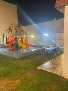una piscina con parco giochi con tavoli e sedie di استراحة بغرفة نوم ومسبح ألعاب مائيه a Ḩarāḑah