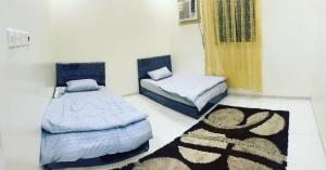 2 letti in una camera con tappeto sul pavimento di استراحة بغرفة نوم ومسبح ألعاب مائيه a Ḩarāḑah