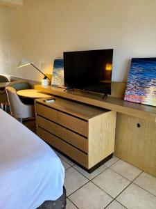 a hotel room with a flat screen tv on a desk at Boundless Bliss Hotel in Nazareth