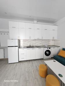 a kitchen with white cabinets and a blue couch at kato's apartment in Tbilisi City +13 photos