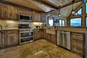 a kitchen with wooden cabinets and stainless steel appliances at Sunset Ridge w Stunning 5 Star Views & Hot Tub in Blue Ridge