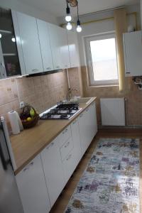 una cocina con armarios blancos y un bol de fruta en la barra en Apartament Cina en Huşi