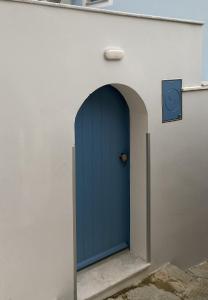 una puerta azul en el lateral de un edificio en Aleminas Rooms, en Symi