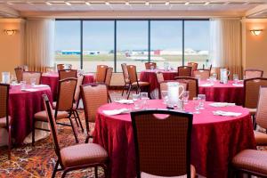 uma sala de conferências com mesas e cadeiras com toalha de mesa vermelha em Sheraton Hartford Hotel at Bradley Airport em Windsor Locks