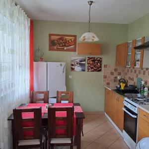 cocina con mesa y nevera blanca en Domki Oaza Spokoju Berezka, en Berezka