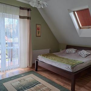 a bedroom with a bed and a large window at Domki Oaza Spokoju Berezka in Berezka