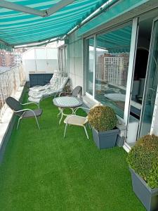 un patio con sillas y una mesa en el césped en Liège centre Médiacité appartement parking gratuit terrasse immense 8ème pour 2 personnes en Lieja