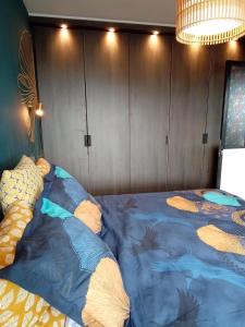 een slaapkamer met een bed met een blauw dekbed bij Liège centre Médiacité appartement parking gratuit terrasse immense 8ème pour 2 personnes in Luik