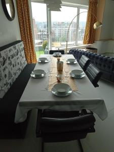 a dining room table with plates and glasses on it at Liège centre Médiacité appartement parking gratuit terrasse immense 8ème pour 2 personnes in Liège