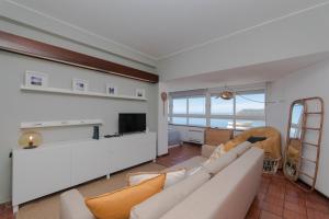 a living room with a couch and a tv at Sesimbra 1111 in Sesimbra